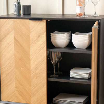 Cabinet with wooden door open, displaying white bowls and plates on shelves.
